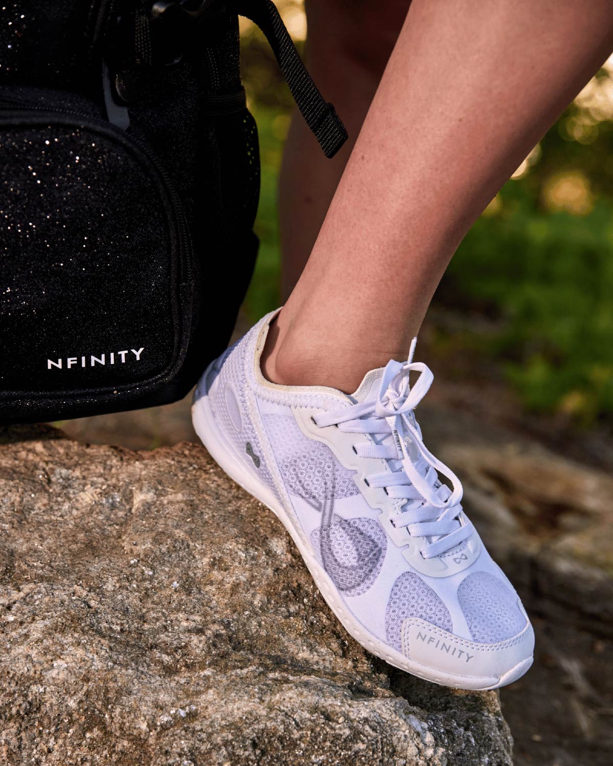 White Nfinity cheer shoe on a rock outdoors