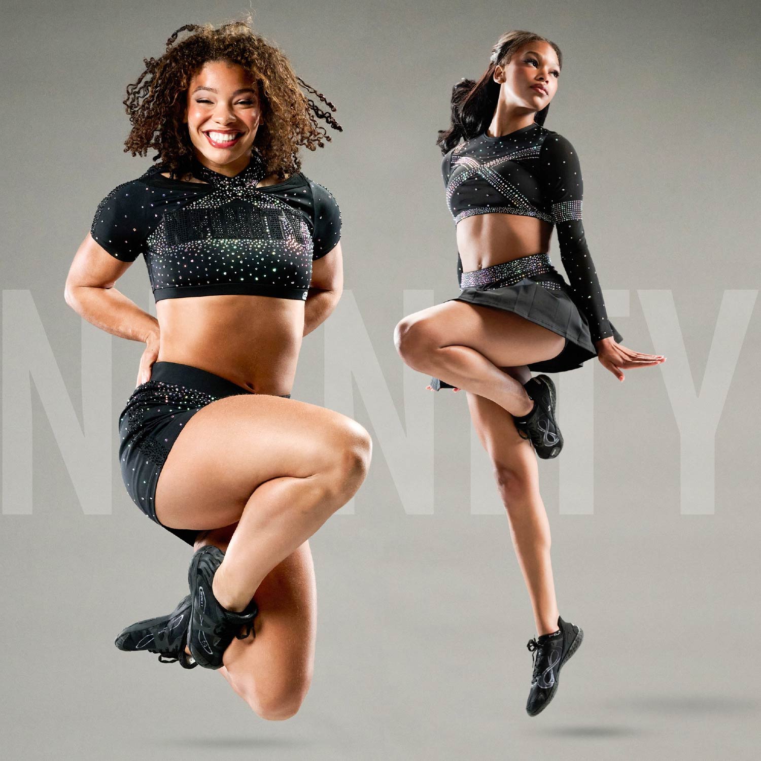 Two cheerleaders mid-jump in black Nfinity competition uniforms